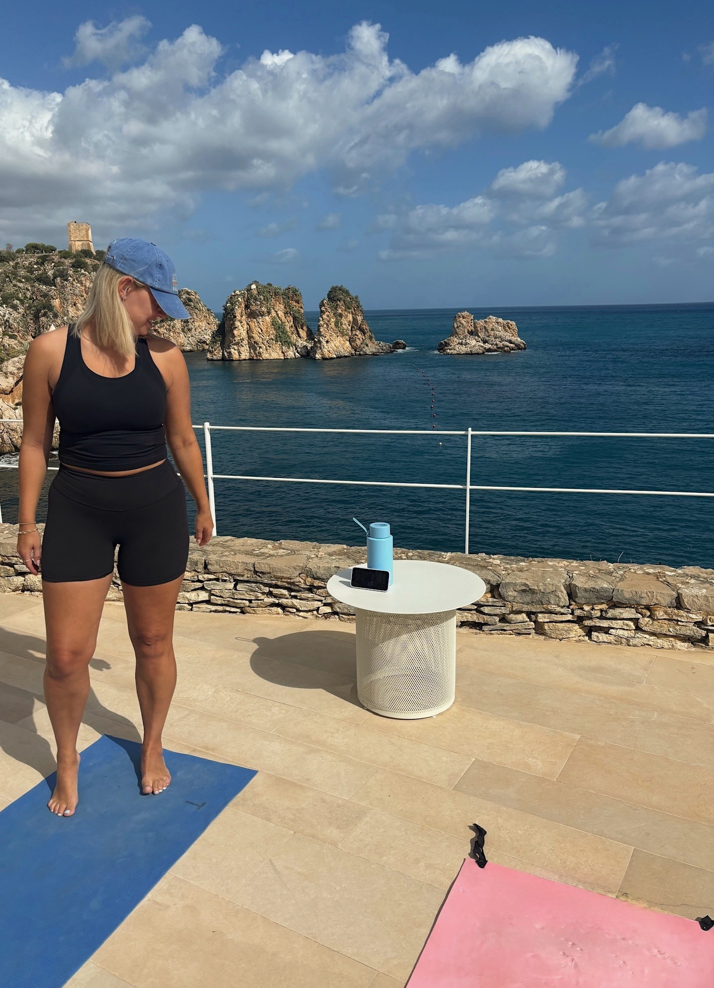 Becky Yates Pilates instructor in Fulham standing on yoga mat by the ocean